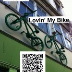 Two green painted BMX bikes sit above a shop door