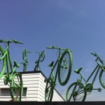 Five green bikes leap from two levels of the rooftop of Putney Leisure Centre